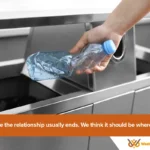 The Integrity Halo: Why the Next Great Brand Relationship Starts at the Recycling Bin 1 Hand depositing plastic bottle into a non-smart stainless steel recycling bin representing the uncertainty of traditional recycling.