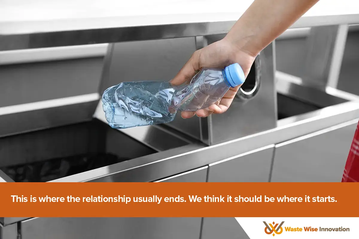 wwi-recycling-relationship-start Hand depositing plastic bottle into a non-smart stainless steel recycling bin representing the uncertainty of traditional recycling.